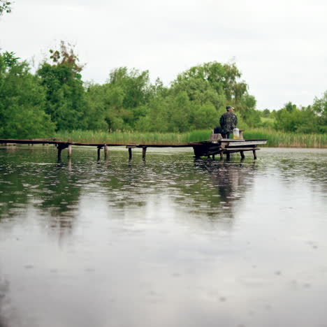 old man is fishing on the old pier. calm leisure of grandfather at nature