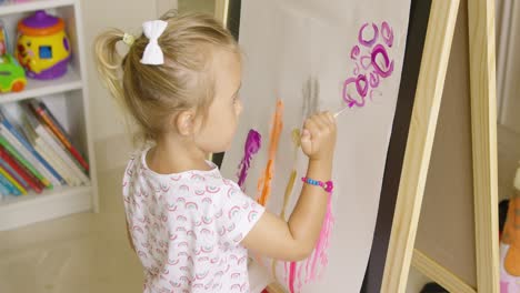 creative little girl painting in a playroom