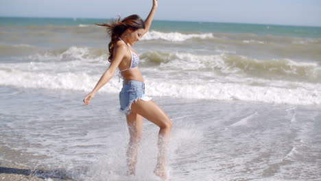 Mujer-Juguetona-Jugando-En-Las-Olas-En-Una-Playa