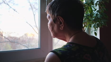 senior woman looking through window
