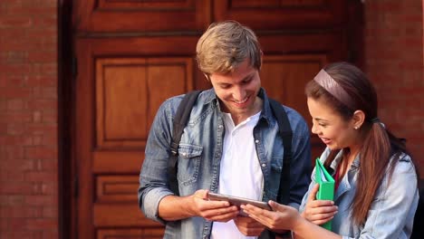 happy students looking at tablet together