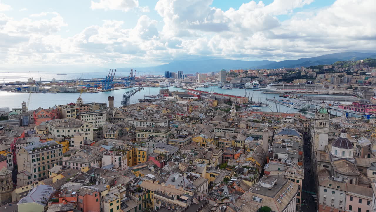 Drone flying forward above Genoa historic center toward colorful port and Mediterranean coast