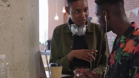 Jóvenes-Empresarios-Afroamericanos-Intercambiando-Ideas-Trabajando-Juntos-Compartiendo-Ideas-Usando-Audífonos-Escuchando-Música-En-Un-Moderno-Lugar-De-Trabajo-De-Oficina