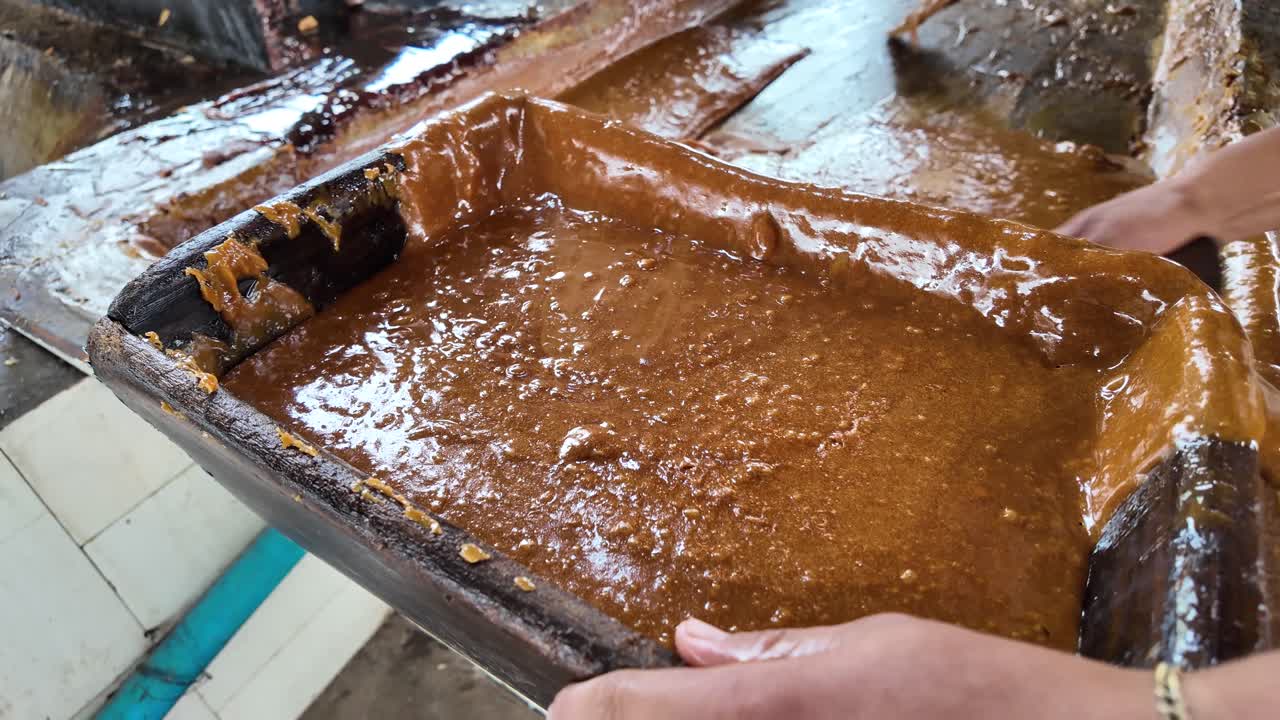 Traditional caramelized sugar being poured into molds to form blocks