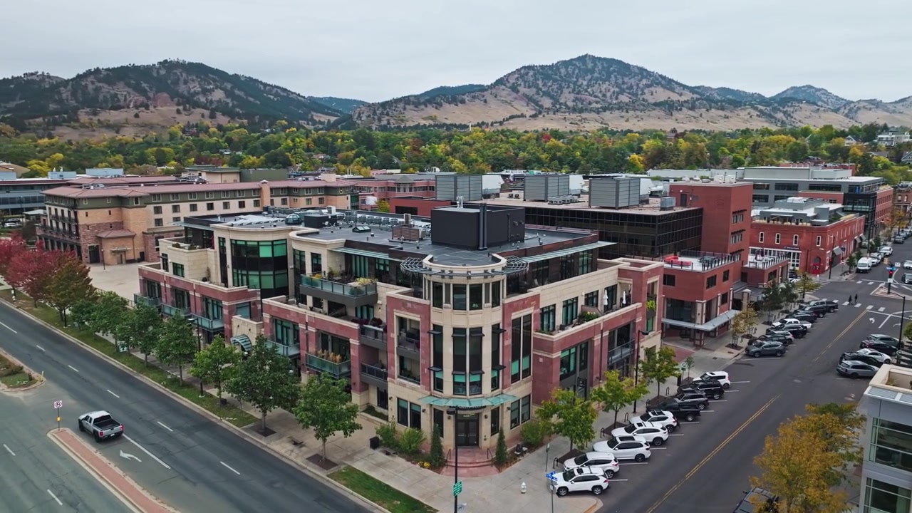 Orbita aerea di case suburbane nel centro di Boulder, Colorado, vicino alle Flatirons, con fogliame autunnale e zone per lo shopping di tendenza.