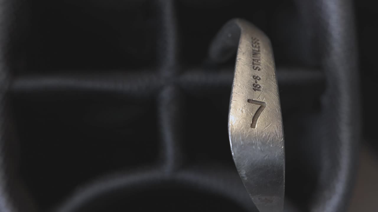 close-up shot of a 7 iron being removed from a golf bag by a golfer