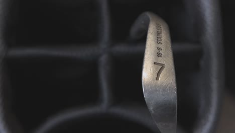 close-up shot of a 7 iron being removed from a golf bag by a golfer