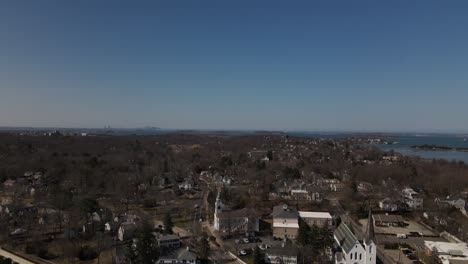 un plano largo y lento descendente de boston, ma usa en la distancia, que revela el pintoresco centro de hingham, ma en primer plano