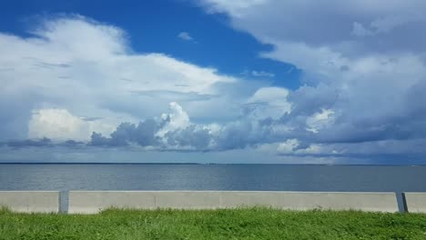 Driving-parallel-to-coast-with-cloudy-sky,-Florida