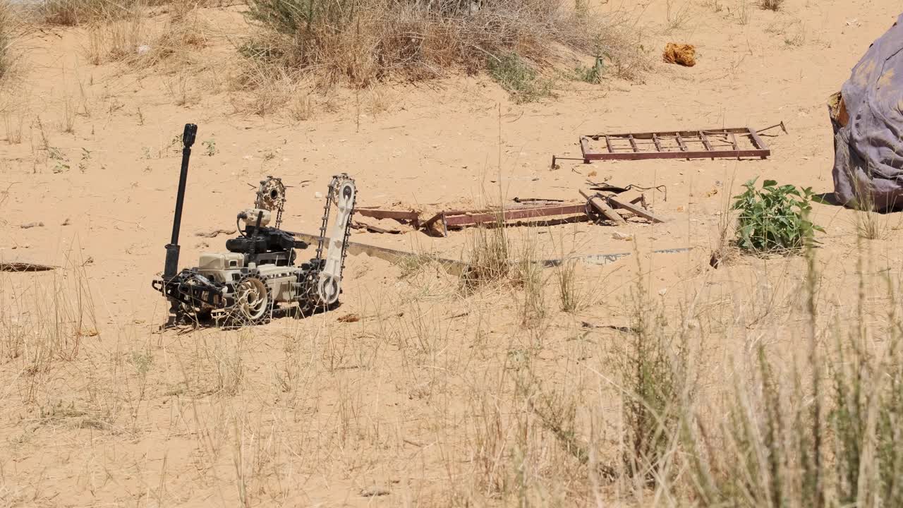 high tech tunnel robot travels on desert sandy land looking for explosives and tunnles hatches