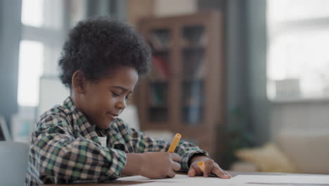 afro boy drawing at home