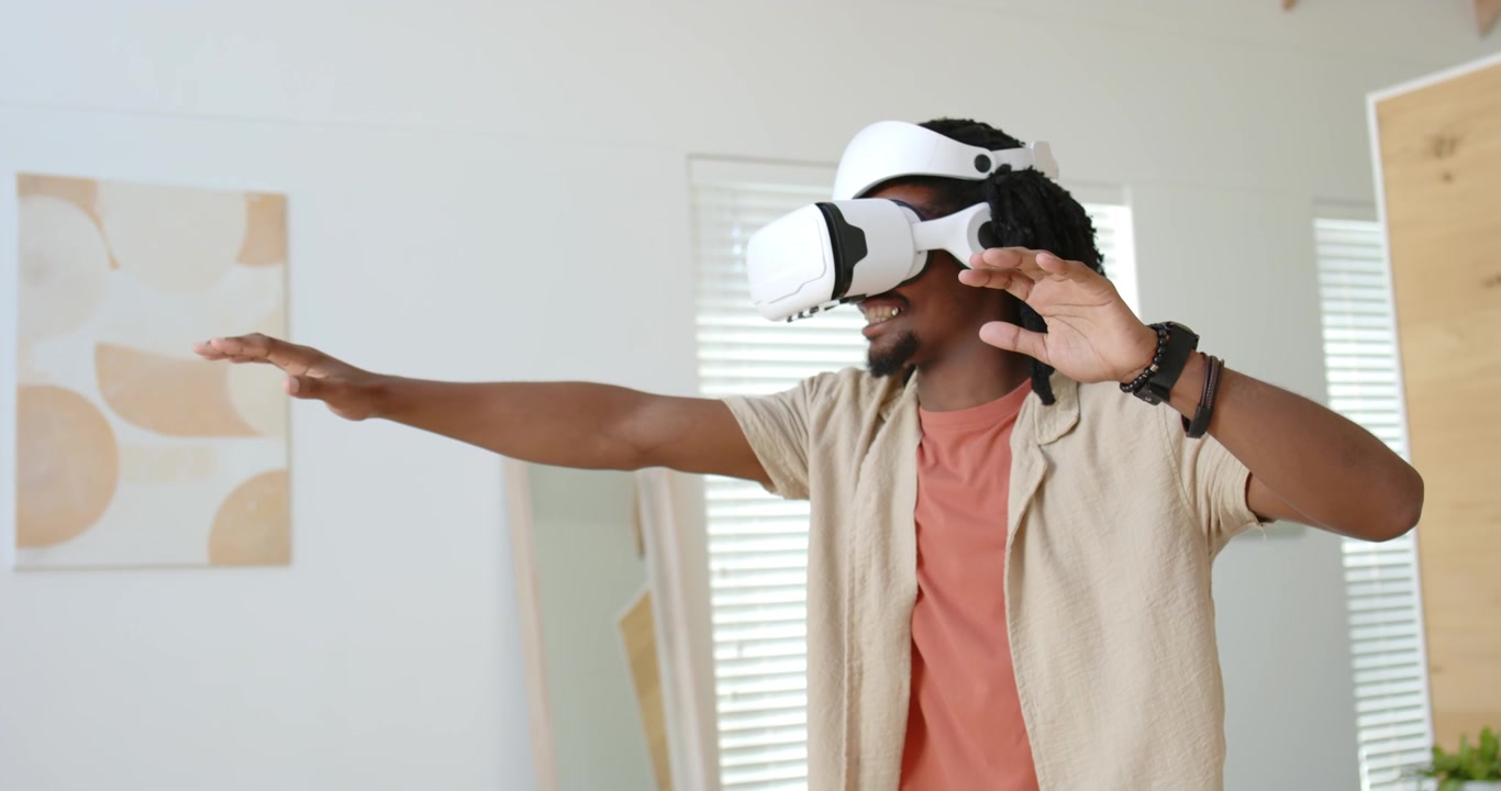 VR in attivazione, uomo adulto afroamericano a casa che si allunga, toccando il visore ed esplorando la scena VR.