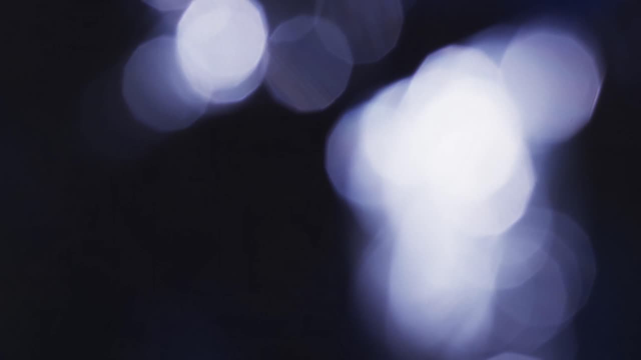 Video di punti luce bokeh bianchi e viola tremolanti con spazio per il testo