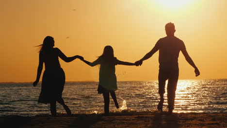 A-Young-Family-With-A-Child-Cuddles-And-Looks-Forward-To-The-Sunset-Over-The-Sea-Good-Time-Together-