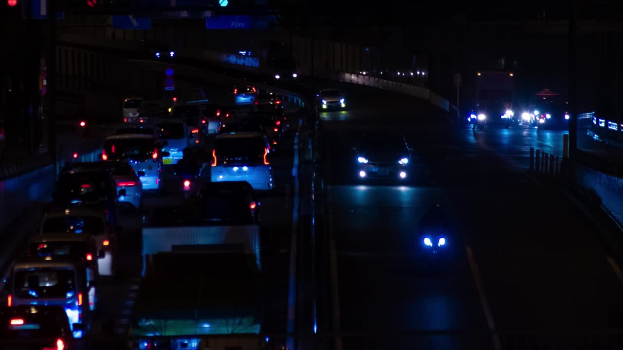 En natt-timelapse av trafikkorken på en bygate i Tokyo, totalbilde.