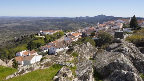 view of marvao village with beautiful houses and church with rocky landscape mountains behind