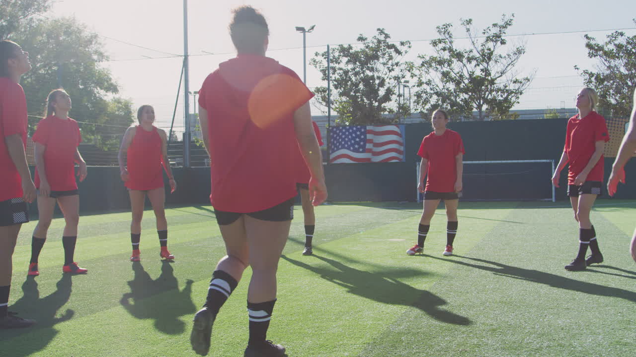Players Kicking Ball As Female Soccer Team Warm Up During Training Before Match