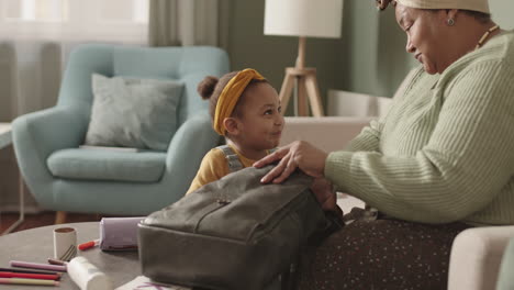grandmother helping her granddaughter preparing for school