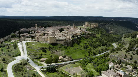 ummauerte stadt pedraza, umgeben von grünen wiesen in der provinz segovia, spanien