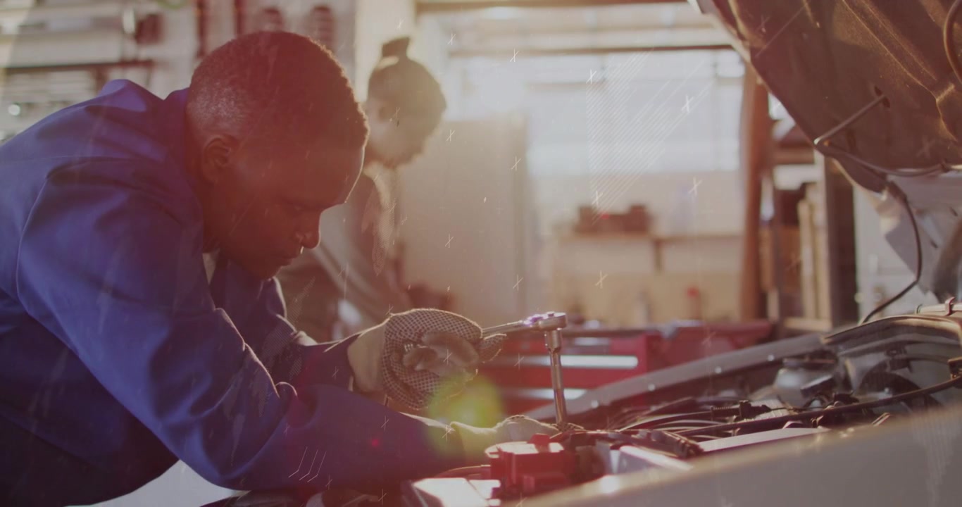 Lead auto tech clipping red clamps, probing engine, causing HUD data while helper steadying repair
