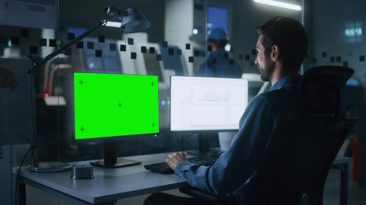 ingeniero trabaja en una computadora, dos pantallas de monitor muestran pantalla verde clave de croma y pantalla de software de hoja de cálculo. moderna industria de alta tecnología 4.0 fábrica de producción de electrónica