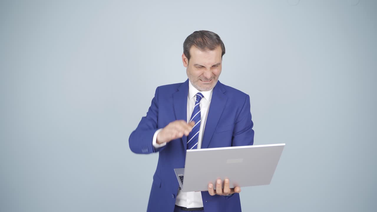 un hombre de negocios enojado cierra su computadora portátil enojado.