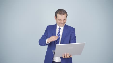 un hombre de negocios enojado cierra su computadora portátil enojado.