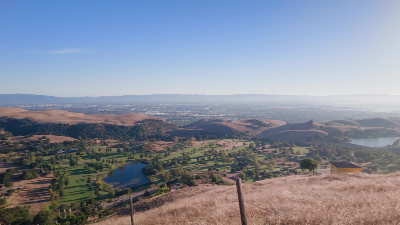 Panoramica fluida verso destra che cattura un vasto paesaggio collinare e viste lontane dalla cima del Monte Drago nella California settentrionale
