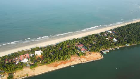 aerial drone shot of a coastal village on an island with coconut trees in udupi