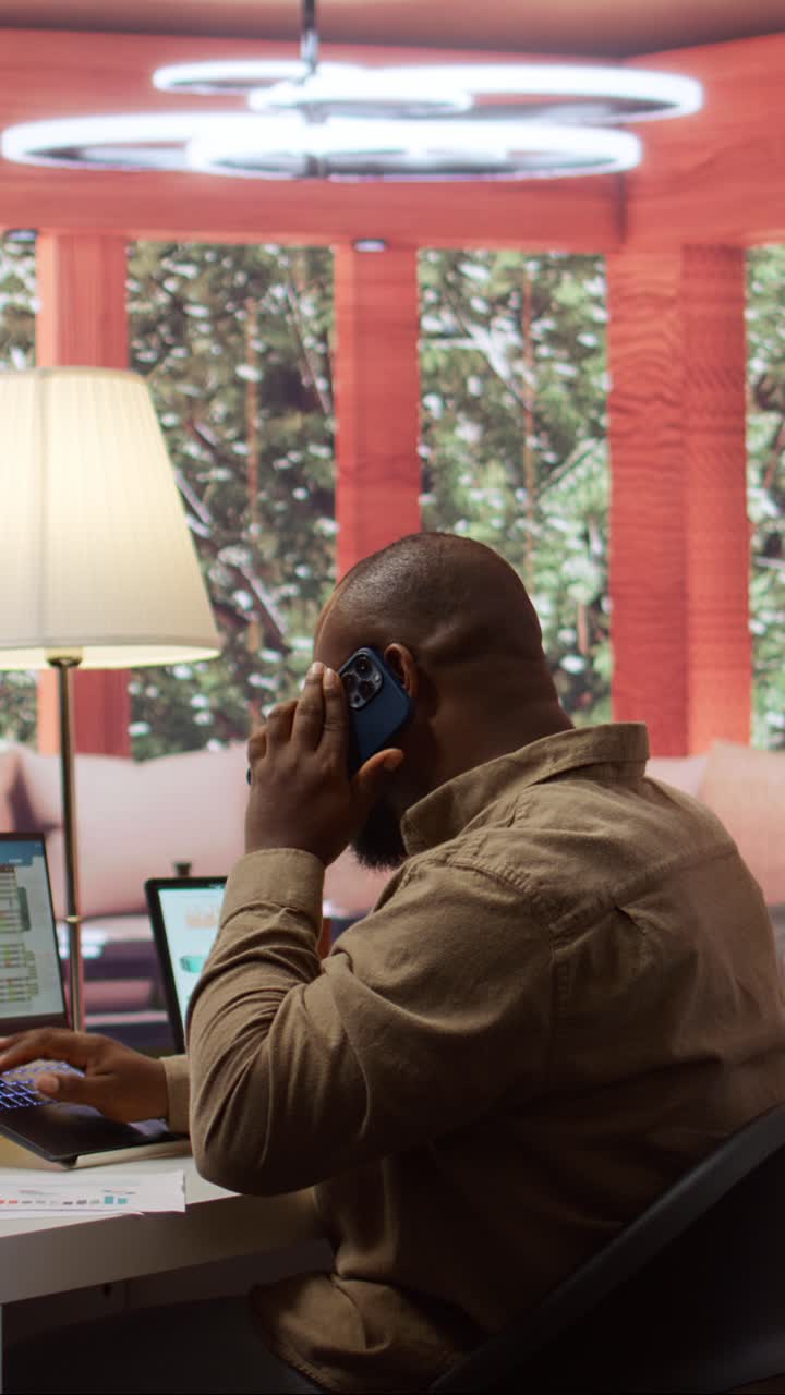 African American Man Working on Laptop and Talking on Phone
