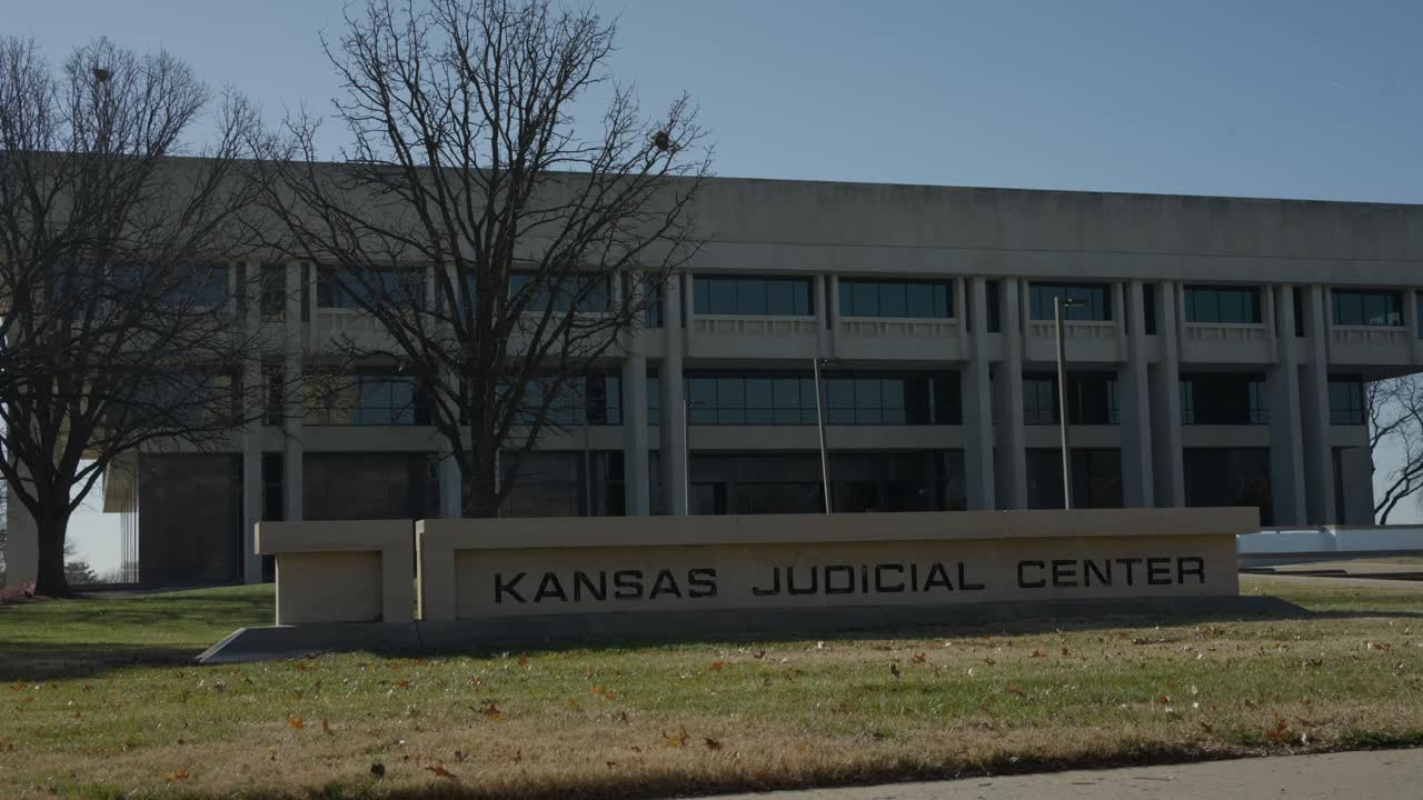 Ripresa fluida con gimbal che si sposta verso l'alto lungo l'esterno di un edificio giudiziario a Topeka, Kansas, mettendo in risalto l'architettura governativa e le infrastrutture civiche. Ideale per contenuti visivi legali, governativi e cittadini.