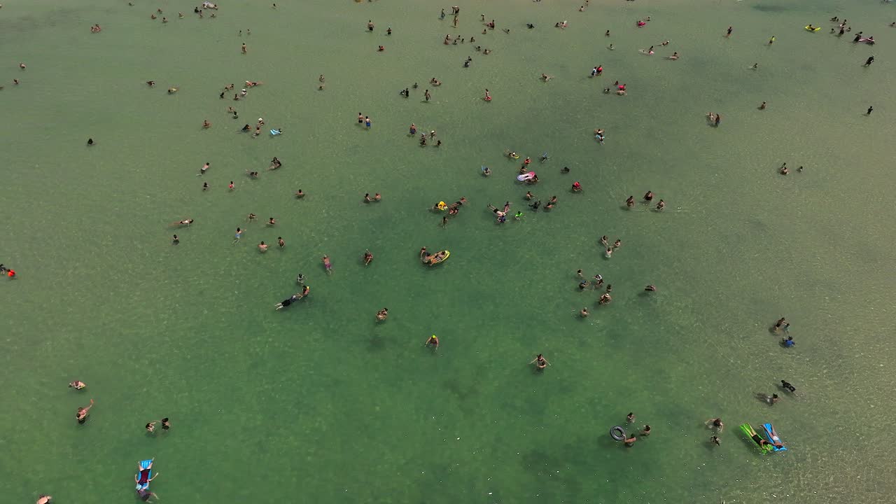 바 ⁇ 가에서 사람들이 물 속에 있고 다채로운 우산  ⁇ 에 있는 여름날, 위아래 드론 영상