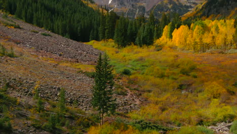 Maroon-Bells-Pyramid-Peak-Aspen-Snowmass-Colorado-wilderness-Incredible-stunning-cinematic-aerial-drone-fall-autumn-colors-snow-covered-Rocky-Mountains-peaks-morning-pan-up-slow-reveal-forward-motion