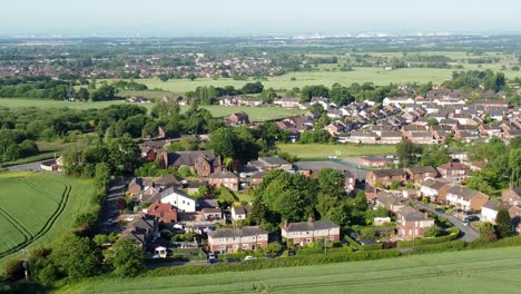 Tomas-Descendentes-De-Drones-De-Las-Idílicas-Tierras-De-Cultivo-De-La-Aldea-De-Cronton-En-El-Reino-Unido-Inglaterra-Con-Vistas-Al-Hermoso-Campo-Con-Casas-Residenciales