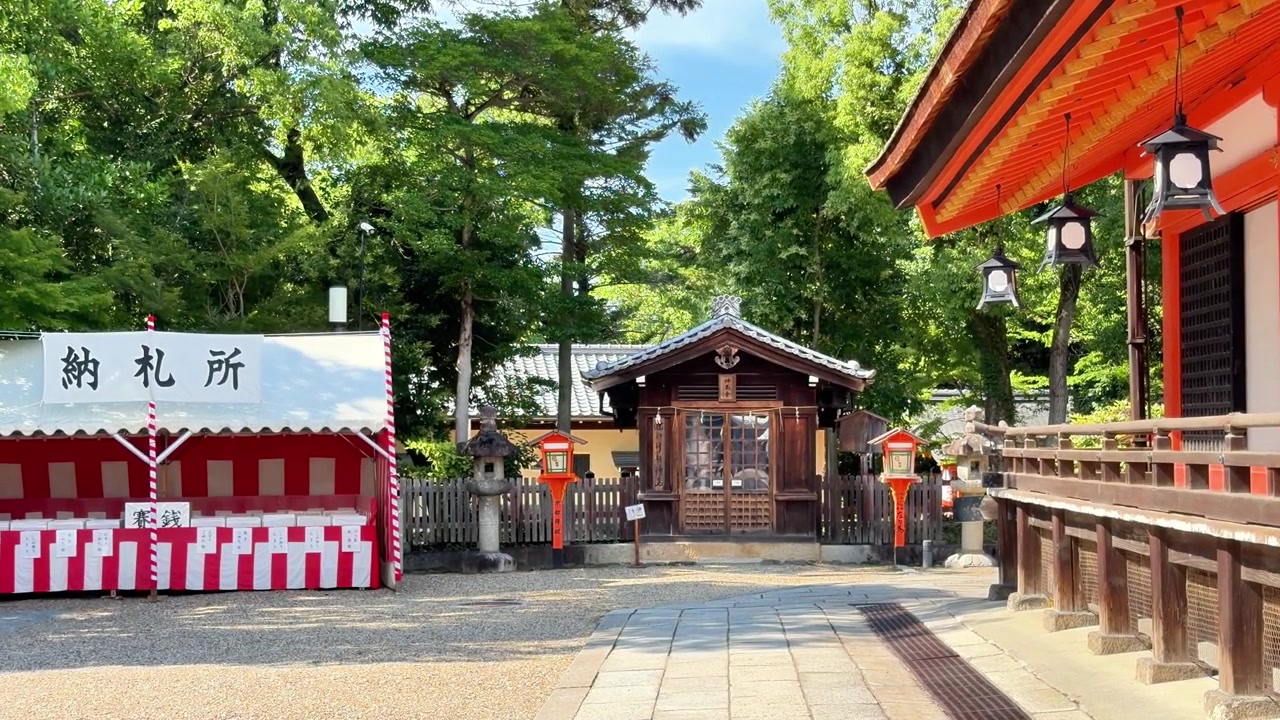 Bâtiments de sanctuaire traditionnels et lanternes dans une cour paisible de Kyoto par une journée ensoleillée