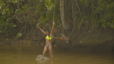 Ein-Mädchen-Kommt-Vom-Schaukeln-Am-Fluss-Herunter-Und-Geht-Auf-Die-Kamera-Zu