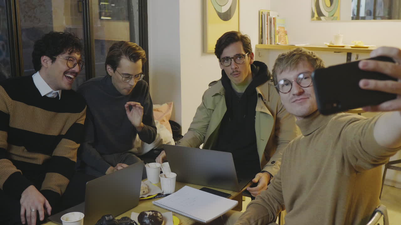 카페에서 스마트폰으로 셀카를 찍는 사업가들. 스마트폰을 사용하는 친구들