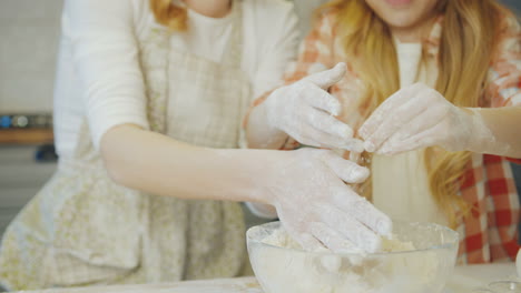 close-up der mit dem kochen beschäftigten mutter und tochter, die sich die hände reiben, weil sie in mehl und daugh in der küche sind. porträt. drinnen