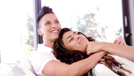 Lesbian-couple-chilling-on-sofa-together