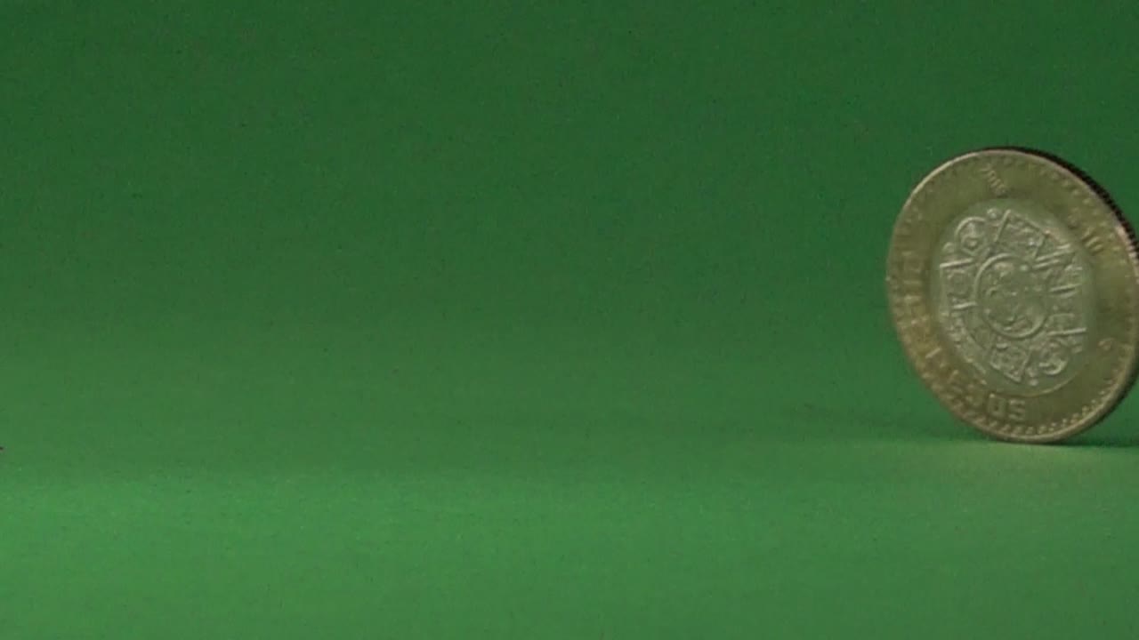 A Mexican coin slowly spinning on a chroma background