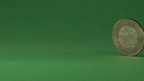 a mexican coin slowly spinning on a chroma background