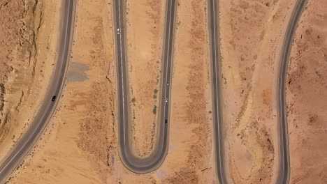 vista aérea del tráfico diurno subiendo y bajando por una carretera sinuosa de la montaña del desierto