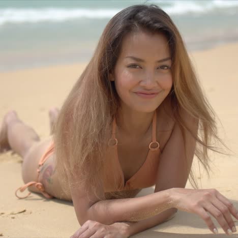 Happy-female-lying-on-sandy-shore