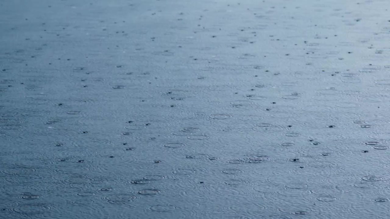Soft blue water surface with gentle ripples and small dark specks. No people or animals visible. Calm, serene, and tranquil atmosphere. Ideal for scenes needing quiet, reflective