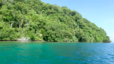 a tropical island paradise and turquoise green blue water from a boat in bougainville, papua new guinea