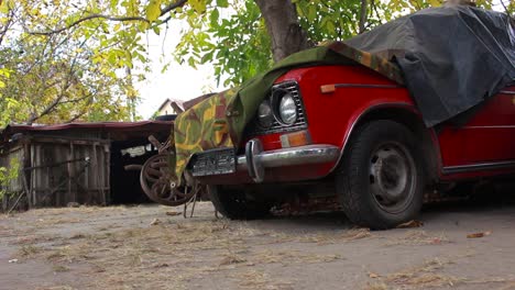 viejo coche rojo abandonado en la granja