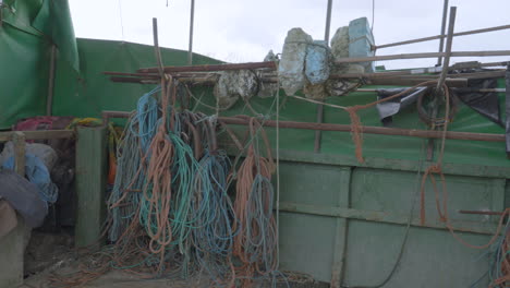 Un-Viejo-Barco-De-Pesca-Con-Equipo-Amarrado-En-Tierra