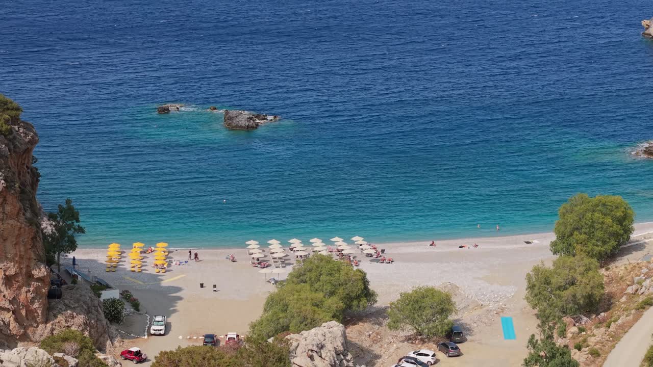 Drone reveals Achata Beach at Karpathos Island, showing turquoise blue waters, sandy shore, and the stunning Mediterranean coastline