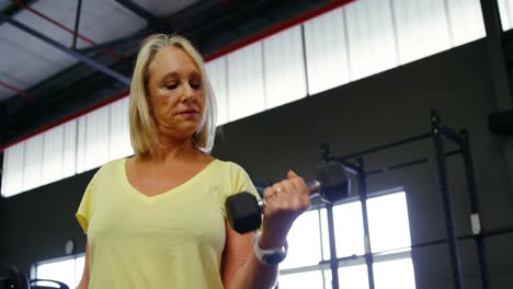 mujer mayor haciendo ejercicio de bíceps con mancuernas 4k