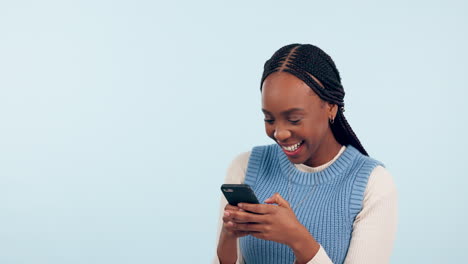 Woman,-laugh-and-typing-with-phone-in-studio